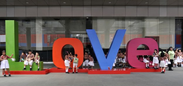 School children walk behind three-dimens